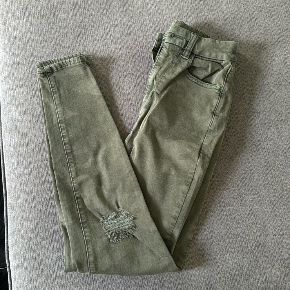 Green camo skinny jeans. Holes in the knee not very big though
